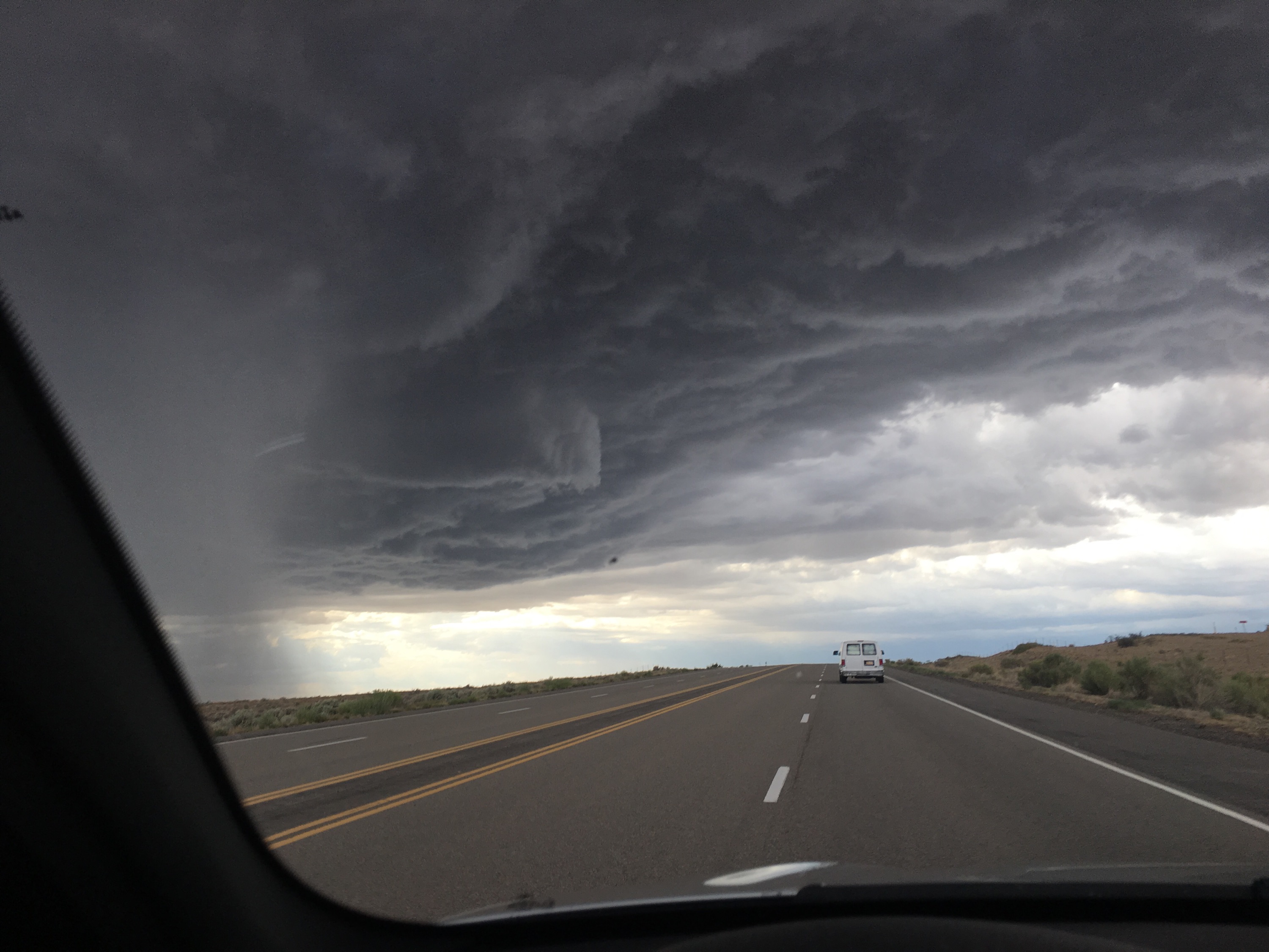 RN, Mary G., driving along the edge of a large storm front near Shiprock, Arizona.